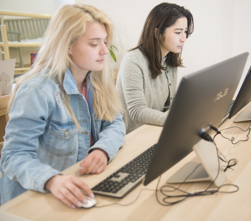 Students studying on computers together.