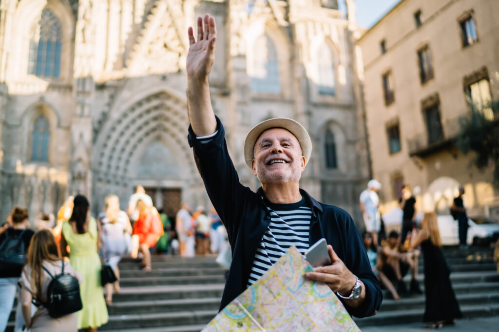 Photo of happy male tourist with modern cellphone technology and paper map for tracking navigation.