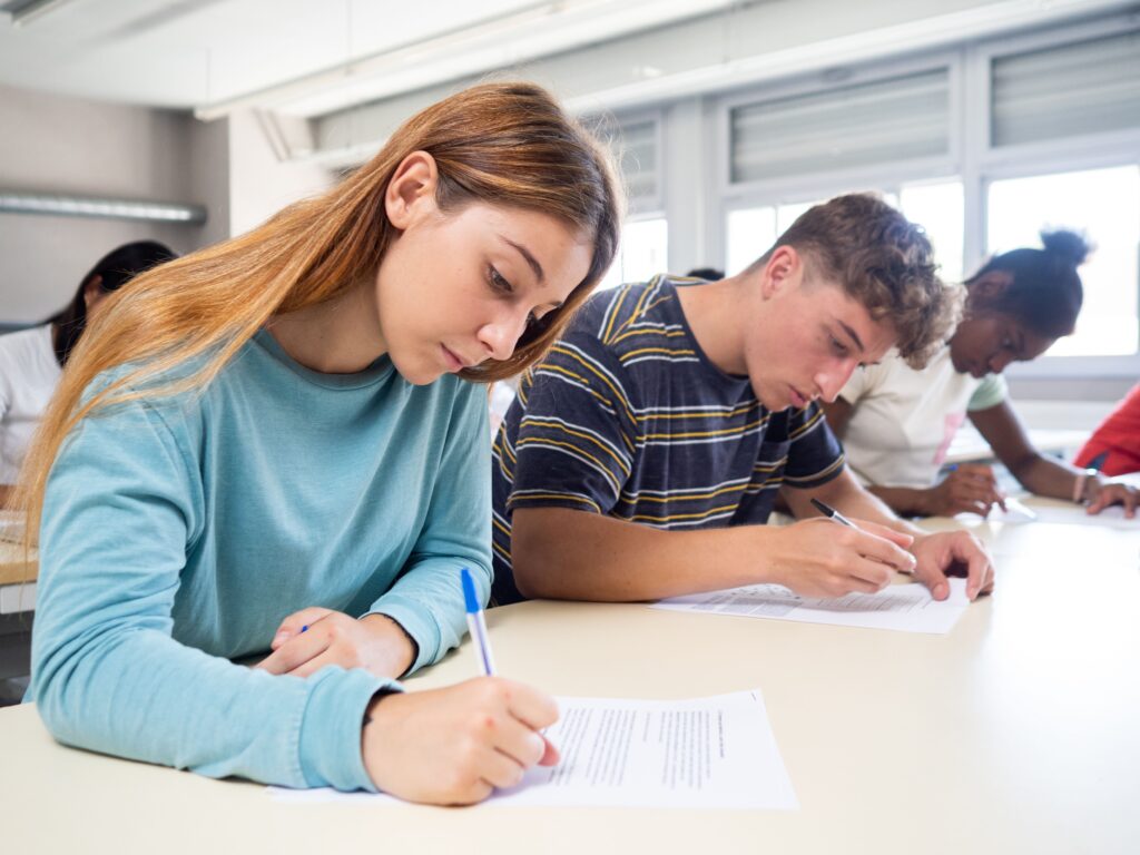 A photo of group of students attentively taking a test in a classroom.