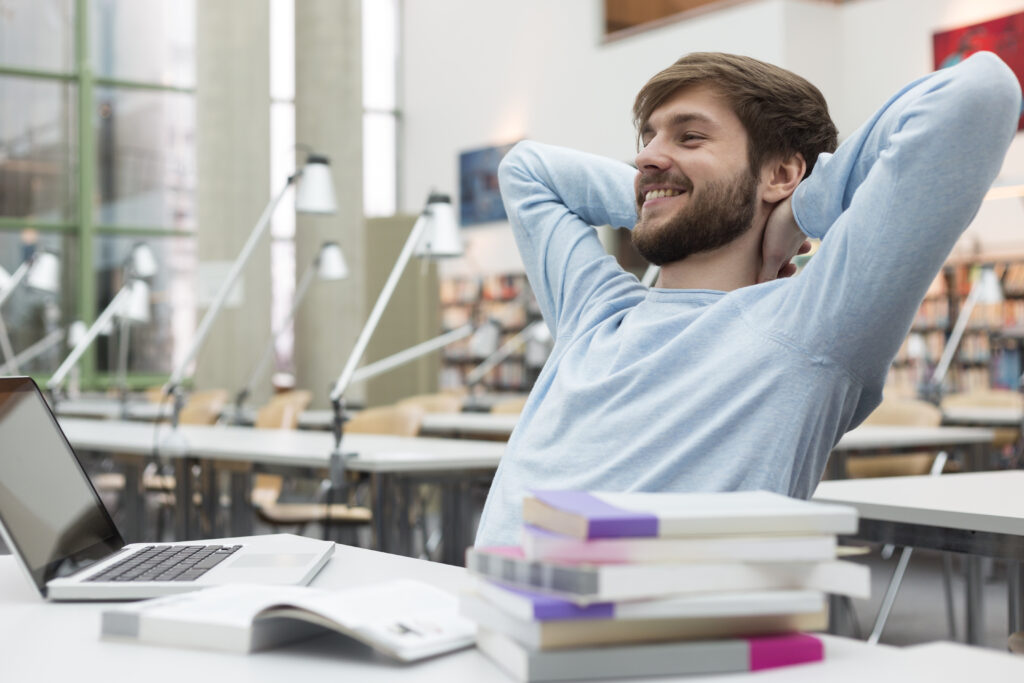 Student leaning back in a university library.
