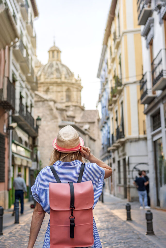Woman tourist exploring old town of Granada Spain, travel concept. Travel alone.