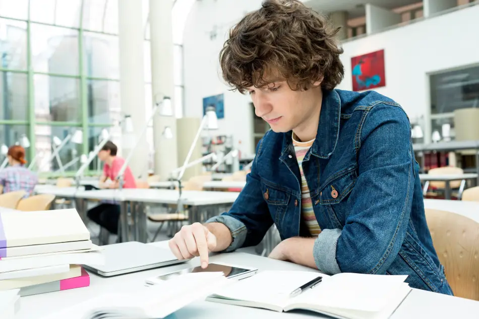 Student studying in a university library. Student studying in a university library.